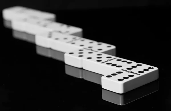 Domino na czarnym tle lśniącej powierzchni — Zdjęcie stockowe