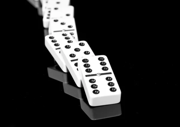 Padlé Domino ležící na černý lesklý povrch — Stock fotografie