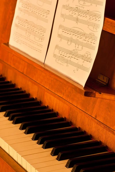 Piano avec musique en feuilles en faible luminosité — Photo