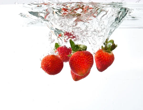 Strawberries dropped into water splash — Stock Photo, Image