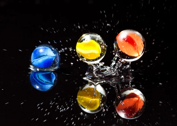Marbles in water splash — Stock Photo, Image