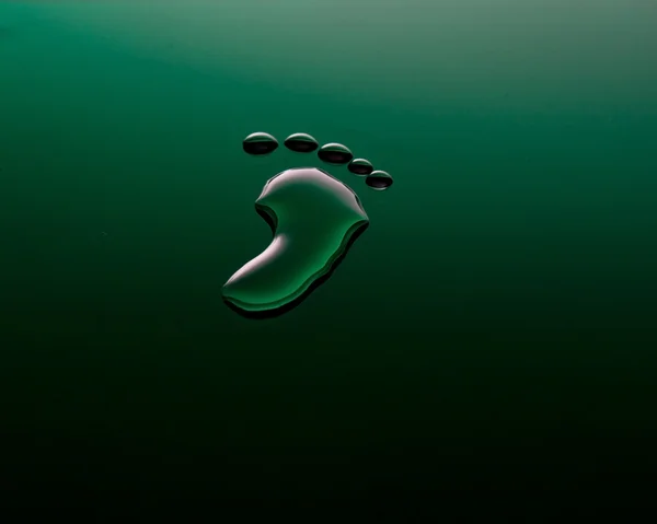 Fußabdruck aus Wasser auf grüner Oberfläche — Stockfoto