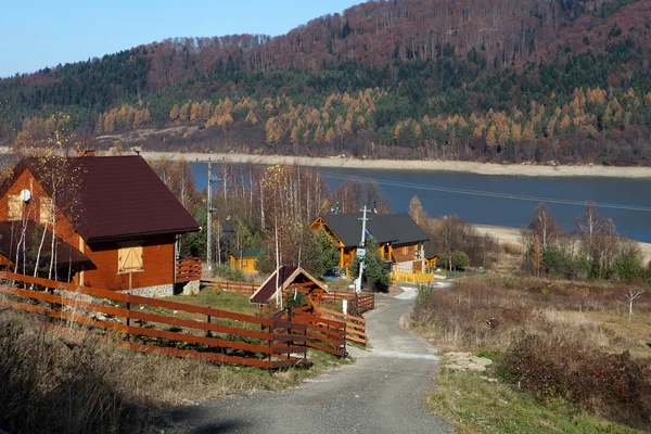 Ξύλινο εξοχικό σπίτι στη λίμνη σε ένα Φθινοπωρινό τοπίο — Φωτογραφία Αρχείου