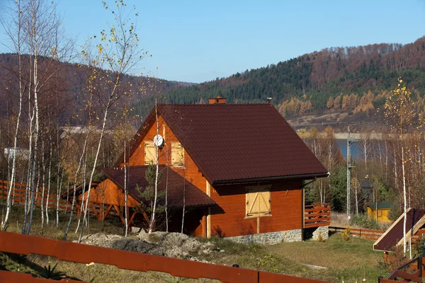 Деревянный коттедж на озере в осеннем пейзаже — стоковое фото