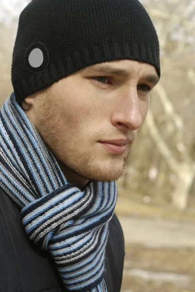 stock image Portrait of young man in black cap and striped scarf