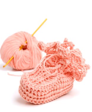 Pink crocheted babby's bootees and thread with crochet clipart