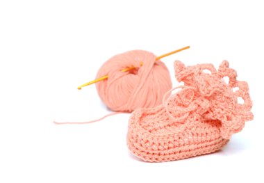 Pink crocheted babby's bootees and thread with crochet clipart