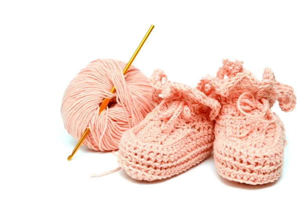 Pink crocheted babby's bootees and thread with crochet — Stock Photo, Image