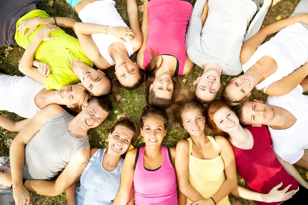 Vänner glada grupp i cirkel tillsammans på gräs — Stockfoto