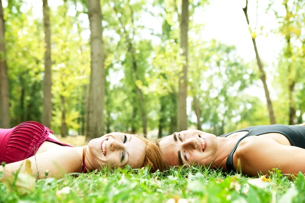 Uśmiechający się para, leżąc na trawie — Zdjęcie stockowe