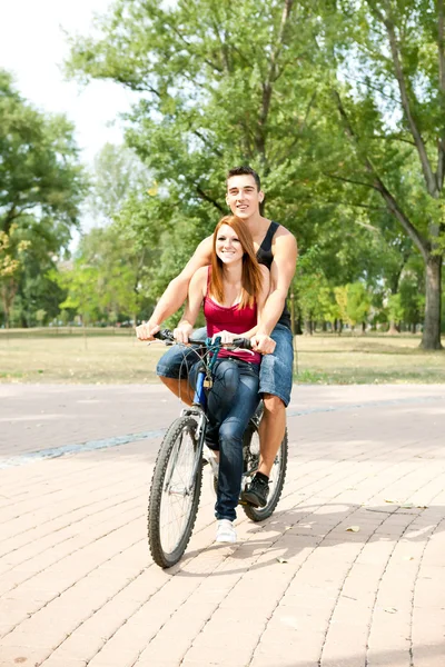 Happy couple riding on a bicycle — Stock Photo, Image
