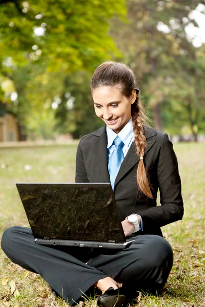 笔记本电脑在公园工作的女商人 — 图库照片