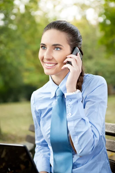 Mujer de negocios con teléfono en el parque — Foto de Stock