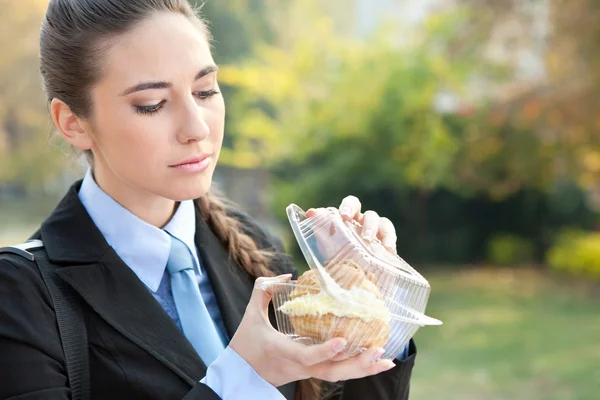 Giovane donna d'affari mangiare una principessa ciambella — Foto Stock