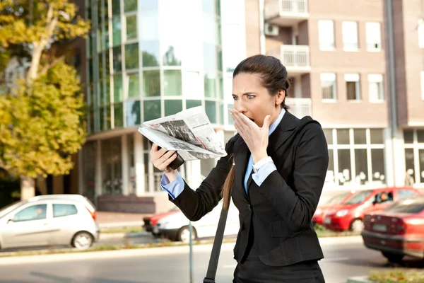 Беспокойная деловая женщина читает газету — стоковое фото