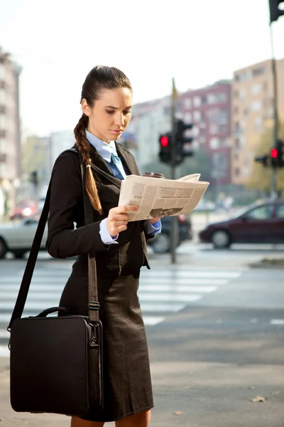 Zakenvrouw naar werk en lezing krant — Stockfoto