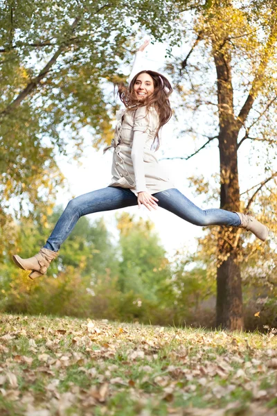 Girl jumping in autumn park — Stock Photo, Image