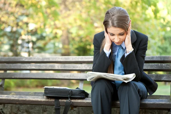 Worry businesswoman reading newspaper — Stock Photo, Image