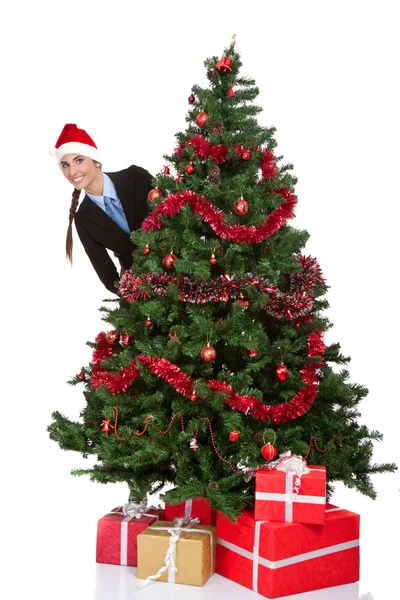 Chica espiando detrás del árbol de Navidad — Foto de Stock
