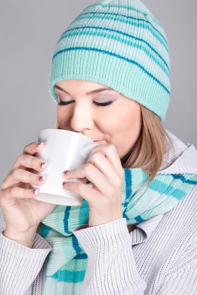 Smiling winter woman holding hot tea — Stockfoto