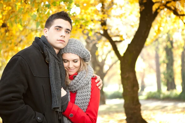 Mladý pár objímat v parku na podzim — Stock fotografie