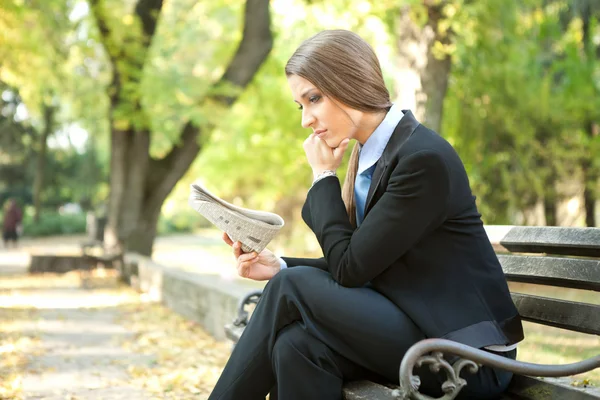 Denkende Geschäftsfrau liest Zeitung — Stockfoto