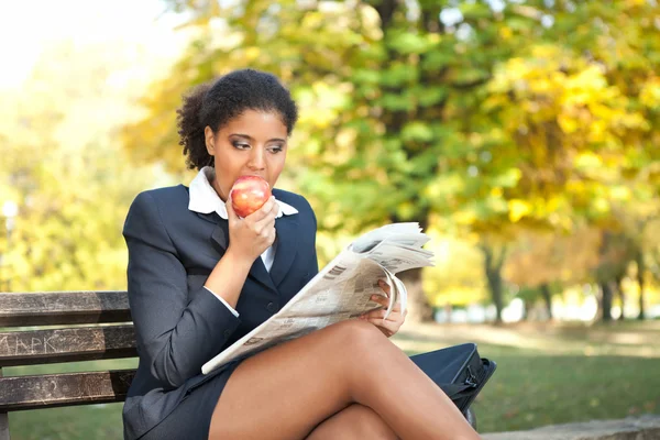 Joven empresaria comiendo manzana — Foto de Stock