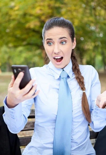 Überraschte Geschäftsfrau schaut in Smartphone — Stockfoto