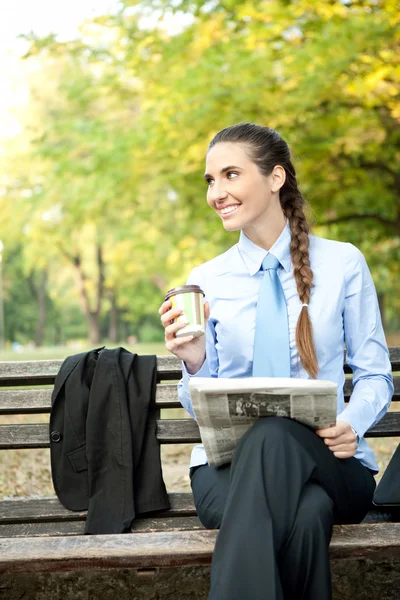 Młoda kobieta z kawy i gazety — Zdjęcie stockowe