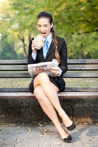 Affärskvinna i park med frukost — Stockfoto