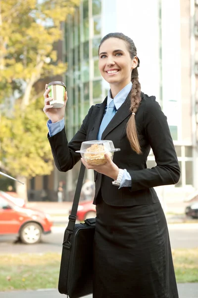 Улыбающаяся деловая женщина с завтраком — стоковое фото