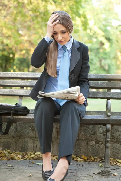 Стрессовая деловая женщина, читающая газету — стоковое фото