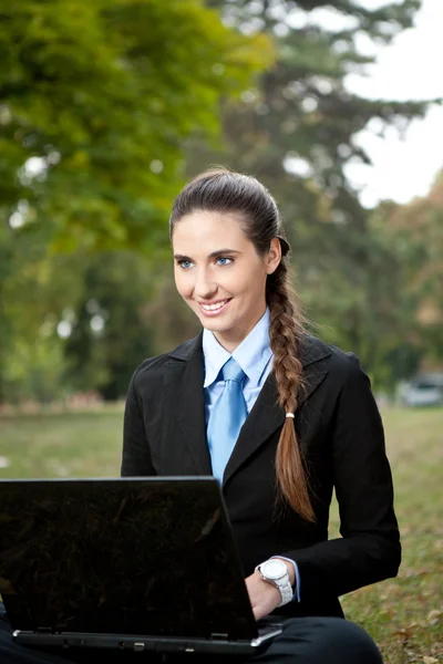 Jonge zakenvrouw werken op gras — Stockfoto