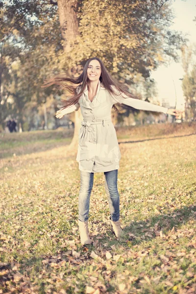 Γυναίκα διασκεδάζοντας στο πάρκο φθινόπωρο — Stockfoto