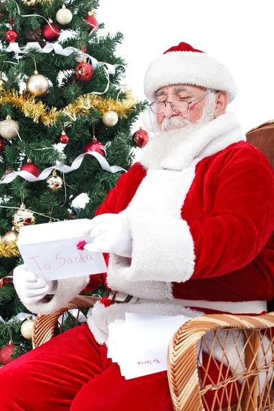 Santa Claus leyendo cartas de regalo para niños para Navidad — Foto de Stock