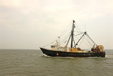 Old, rusty fishing trawler in early morning mist clipart