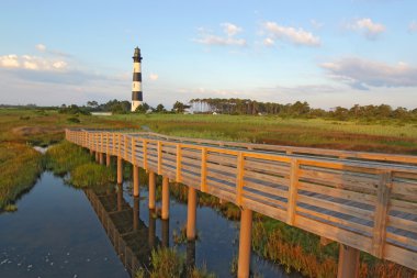 Walkway over a marsh to the Bodie Island lighthouse clipart