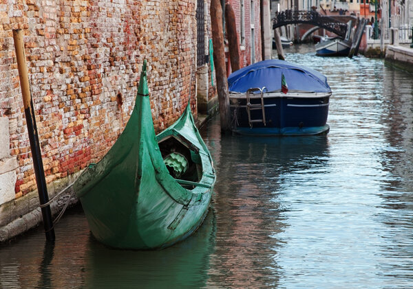 Image of a green gondola on a small Venetian canal.