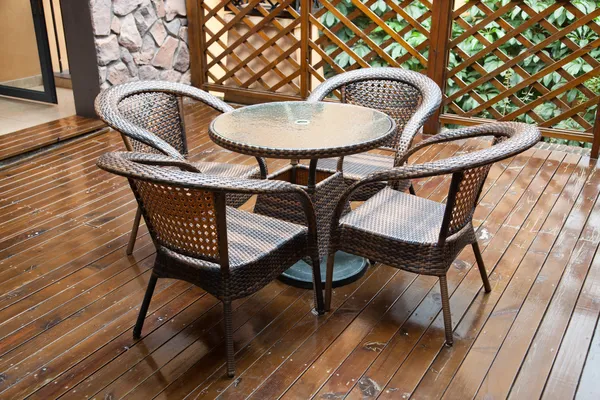 Rieten stoelen en tafel op het hardhout voorste dek — Stockfoto