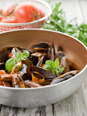 Mussel with tomato sauce and basil over casserole clipart