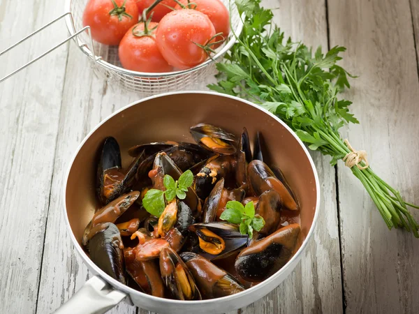Mussel with tomato sauce and basil over casserole — Stock Photo, Image