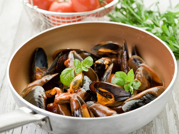 Mussel with tomato sauce and basil over casserole — Stock Photo, Image