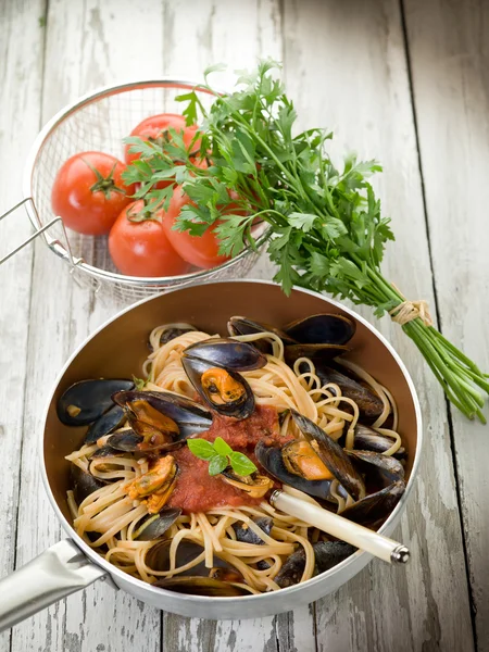 Espaguetis con mejillones y salsa de tomate sobre cazuela —  Fotos de Stock