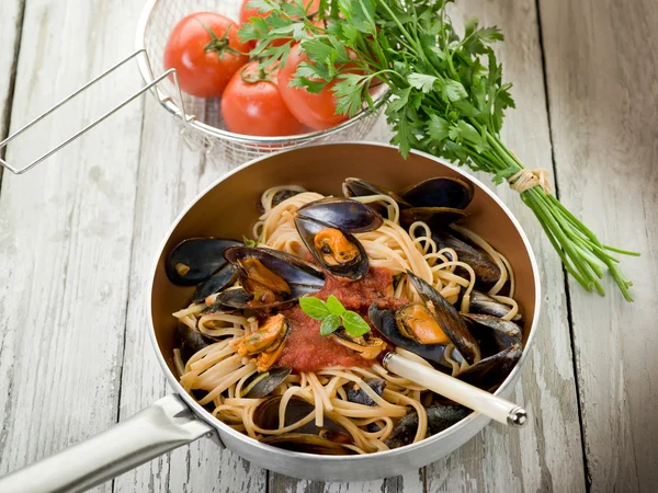Espaguete com mexilhões e molho de tomate sobre caçarola — Fotografia de Stock