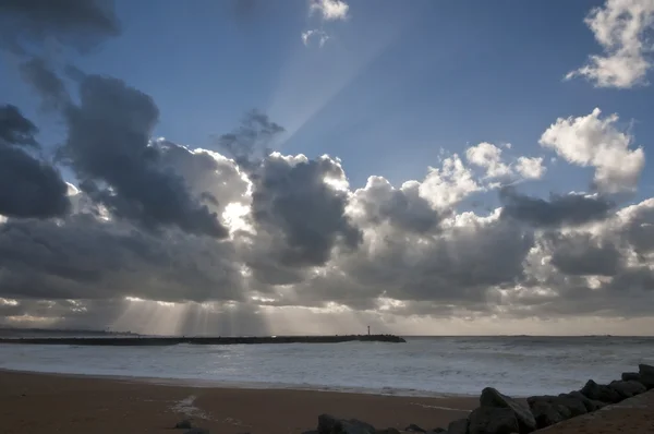 Veel zonlicht stralen door grote wolken boven de zee — Stockfoto