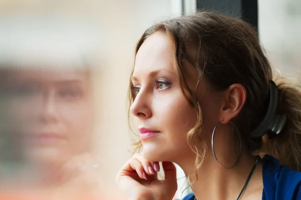 Young woman looking through a window