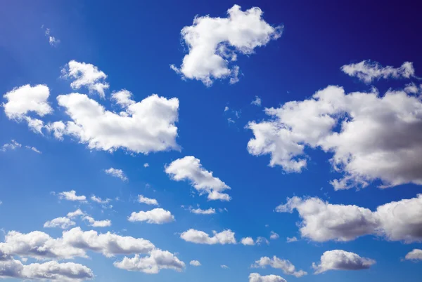 A kék eget fehér felhők borítják. — Stock Fotó