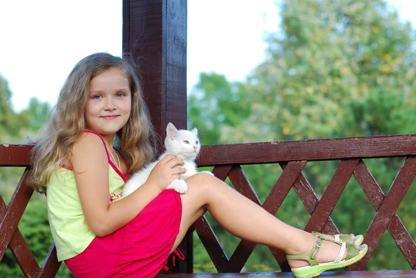Das kleine Mädchen mit einem weißen Kätzchen — Stockfoto