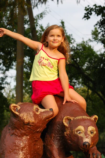 Маленька дівчинка на бурому ведмедику — стокове фото