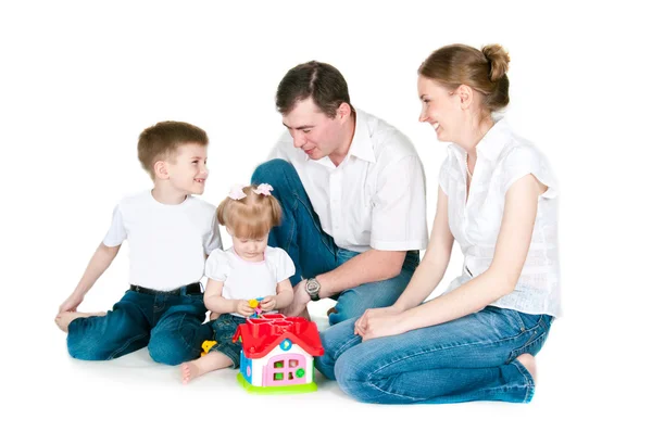 Famiglia felice vicino a una piccola casa giocattolo — Foto Stock